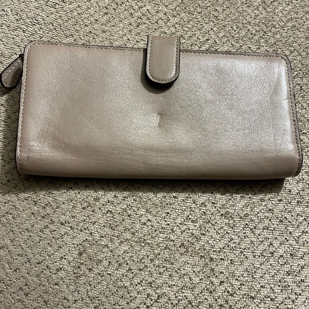 Coach wallet. Has some wear marks and wrinkles on outside of wallet.
